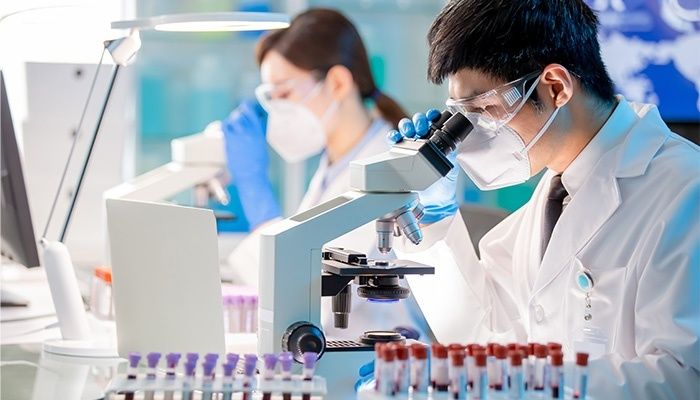Forskare i skyddsutrustning analyserar prover i ett laboratorium
